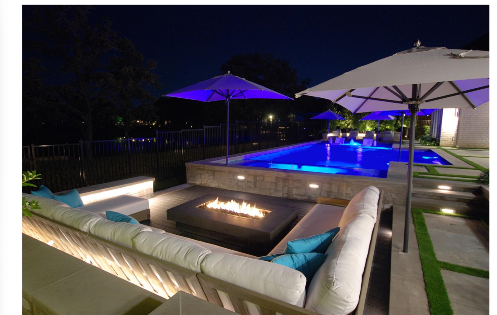Modern Pool Courtyard fire table and pool at night - luxury landscape design by Original Landscape Concepts in Southlake, Texas